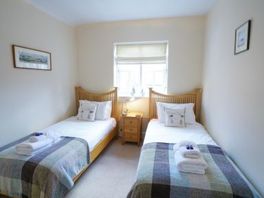 A bedroom with two single beds and a bedside table between them at The Hideaway in Aldeburgh