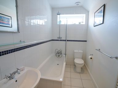 A bathroom with a bathtub shower toilet and sink at The Hideaway in Aldeburgh