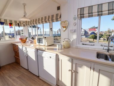A kitchen with countertop appliances a microwave kettle and sink at Valetta Thorpeness in Thorpeness