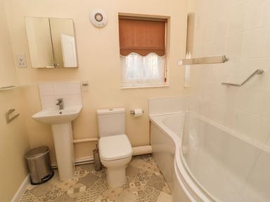 A bathroom with a toilet sink bathtub and a window at Winkle Cottage Aldeburgh