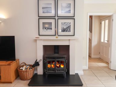 A living room with a fireplace and pictures on the wall at Seadrift Dunwich Near Westleton