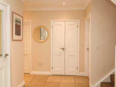 A hallway with double doors and a mirror at Seadrift Dunwich Near Westleton