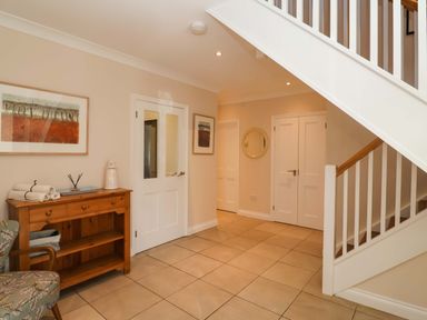 A hallway with a table and towels at Seadrift in Dunwich Near Westleton