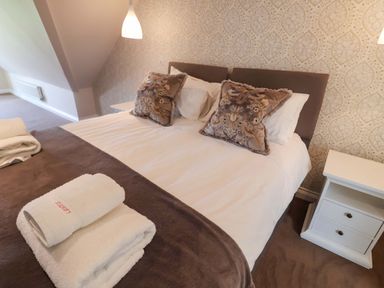 A bedroom with a bed and bedside table at Seadrift in Dunwich Near Westleton