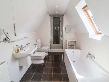 A bathroom with a bathtub, shower, sink and toilet at Seadrift in Dunwich Near Westleton