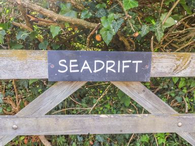 A sign on a gate with the name Seadrift Dunwich Near Westleton