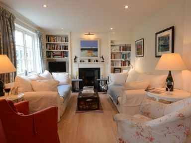 A living room with sofas a fireplace bookshelves and lamps at 2 The Bays Thorpeness