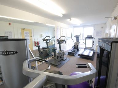 A gym room with exercise bikes treadmills rowing machine and weight equipment at Saffron Blythview in Blythburgh near Southwold