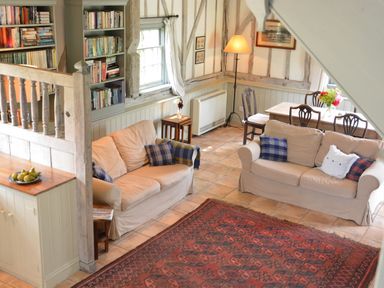 A living room with two beige sofas and a wooden dining table with chairs at The Gig House in Stowupland