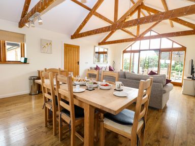 A dining room with a wooden table and chairs at The Mulberry, nr Bungay