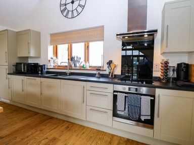 A kitchen with cabinets, countertop, sink, and appliances at The Mulberry, nr Bungay
