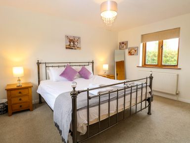 A bedroom with a bed and bedside table at The Mulberry, nr Bungay