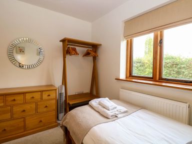 A bedroom with a bed and dresser at The Mulberry, nr Bungay