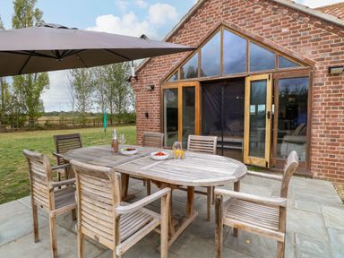An outdoor dining area with a table and chairs at The Mulberry, nr Bungay