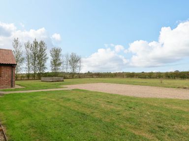 A garden with grass, a pathway, and a gravel area at The Mulberry, nr Bungay Bungay