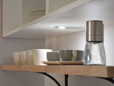 A wooden kitchen shelf with cups, bowls, and a glass jar grinder at Milk Parlour Spexhall Near Halesworth