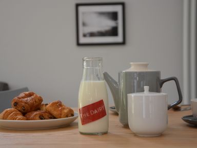 A table with a plate of pastries a bottle of milk a teapot and a sugar bowl at Milk Parlour Spexhall Near Halesworth