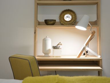 A wooden desk with a white lamp a white jar a glass container a wooden bowl and a framed mirror with a yellow chair at Red Poll Barn Spexhall Near Halesworth