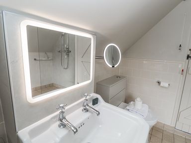 A bathroom with a wash basin and shower at Mariners Cottage, King Street in Aldeburgh