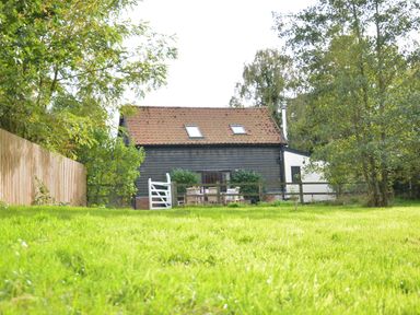 A house with a tiled roof surrounded by trees and a lawn at Wheelwright's Barn Walpole Near Halesworth