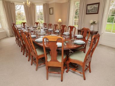 A dining room with a large table set for dinner at Henstead Hall Henstead near Beccles