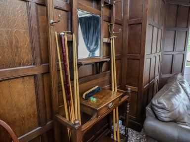 A living room with a coat rack and wooden table at Henstead Hall in Henstead near Beccles