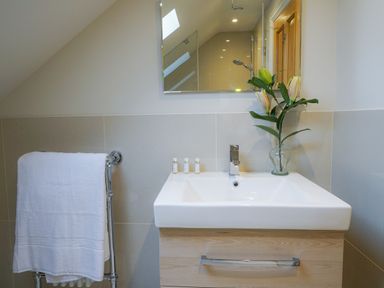 A bathroom sink with a mirror above and a towel hanging on a rack at 10 Church Walk Aldeburgh