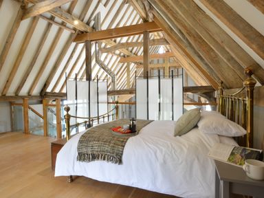A bedroom with a brass bed and wooden beams at Manor House Barn Peasenhall