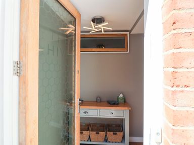 An entryway with a table and baskets at The Hive, Southwold
