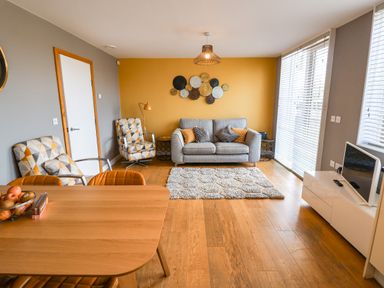 A living room with seating and a table at The Hive, Southwold