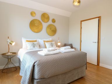 A bedroom with a bed and wall decor at The Hive, Southwold