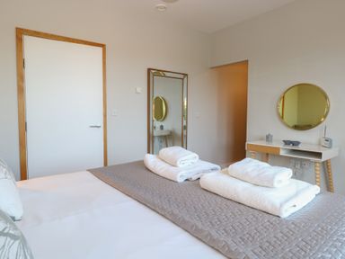 A bedroom with a bed and towels arranged at The Hive, Southwold