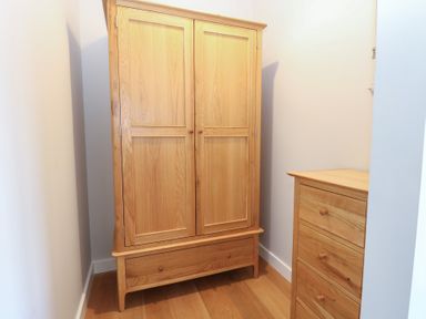 A wardrobe and a chest of drawers in a bedroom at The Hive, Southwold