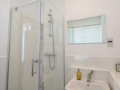 A bathroom with a shower and sink at The Hive, Southwold