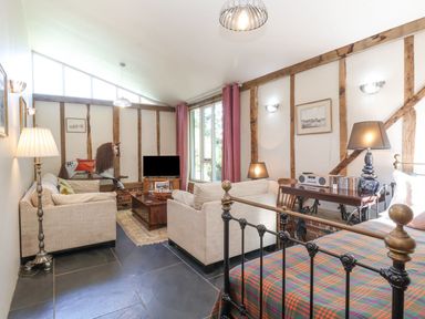 A living room with a TV and sofa at Yew Tree Farm Barn and Stable in Framlingham