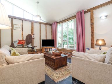 A living room with a coffee table and a television at Yew Tree Farm Barn and Stable in Framlingham