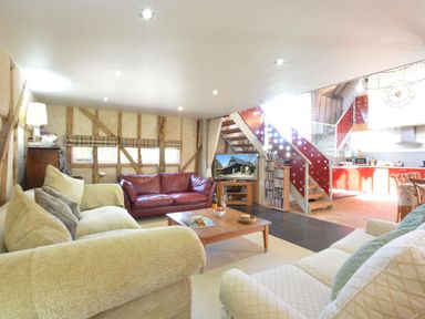 A living room with a sofa and television at Yew Tree Farm Barn and Stable in Framlingham