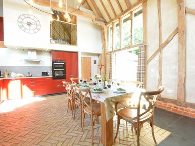 A dining room with a table set for a meal at Yew Tree Farm Barn and Stable Framlingham