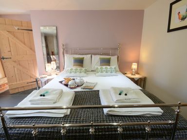 A bedroom with a bed and bedside table at Yew Tree Farm Barn and Stable in Framlingham