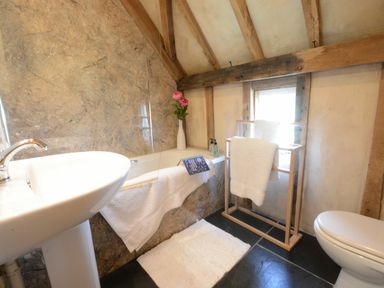 A bathroom featuring a bathtub, sink, and towel rack at Yew Tree Farm Barn and Stable in Framlingham