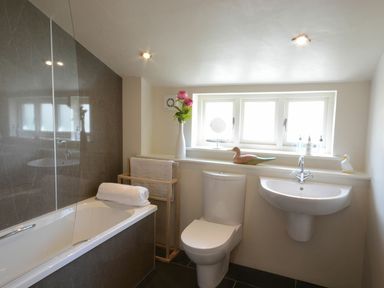 A bathroom featuring a bathtub, toilet, and sink at Yew Tree Farm Barn and Stable Framlingham