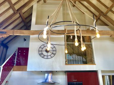 A kitchen with a chandelier and clock at Yew Tree Farm Barn and Stable Framlingham