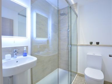 A bathroom with a sink mirror shower enclosure and toilet at Skylight Aldeburgh in Aldeburgh