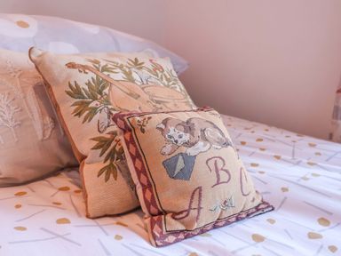 A bed with decorative pillows in a bedroom at Pine Cottage in Woodbridge