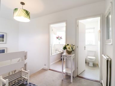 A hallway with two open doors leading to a bathroom and a toilet at The Bridge House Southwold