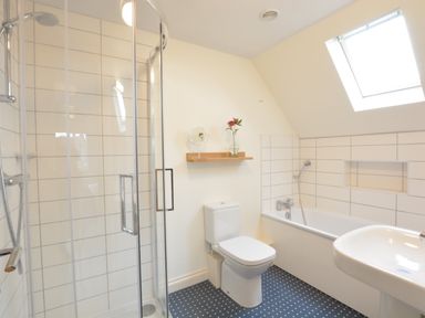A bathroom with a shower cubicle toilet bathtub and sink at Mellows Thorpeness in Thorpeness