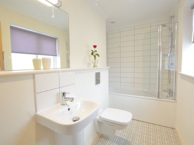 A bathroom with a sink toilet bathtub and tiled floor at Mellows Thorpeness in Thorpeness
