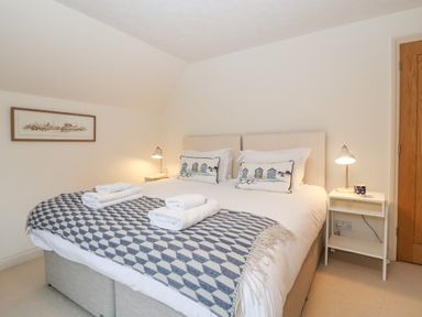 A bedroom with a double bed side tables and lamps at Mellows Thorpeness