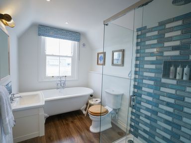A bathroom with a clawfoot bathtub sink toilet and glass shower at Shingle Skies Aldeburgh in Aldeburgh