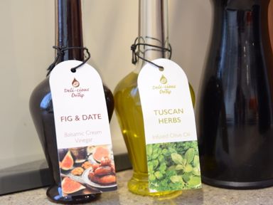 Bottles of fig and date balsamic cream vinegar and tuscan herbs infused olive oil with labels